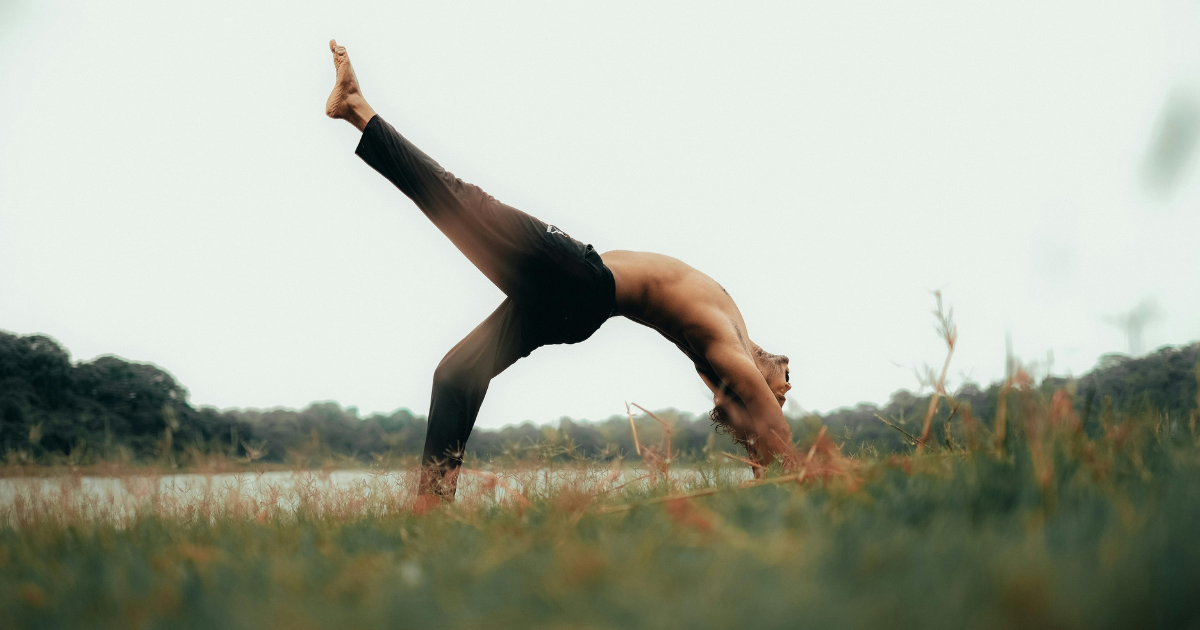 A man performing a strong yoga pose as part of his self-care routine.