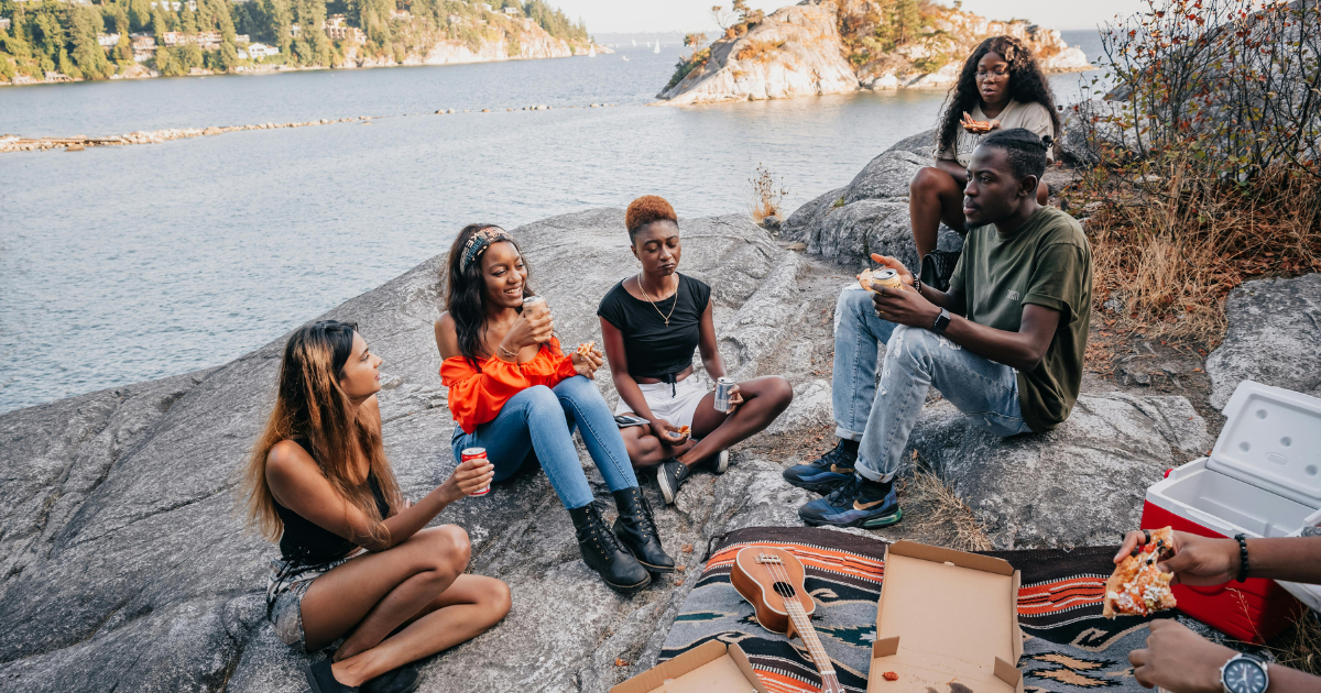 Group of friends celebrating picnic happily, emphasizing the significance of choosing the right social circle in the journey of personal transformation.