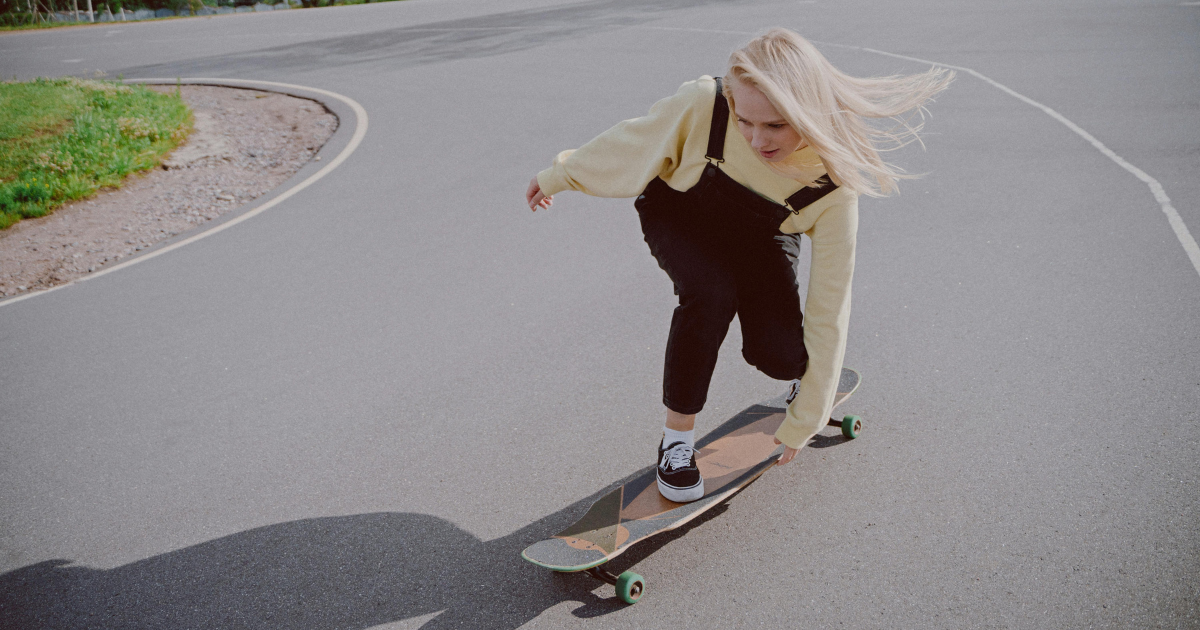 A woman skating alone between roads, symbolizing the pursuit of her own best self.