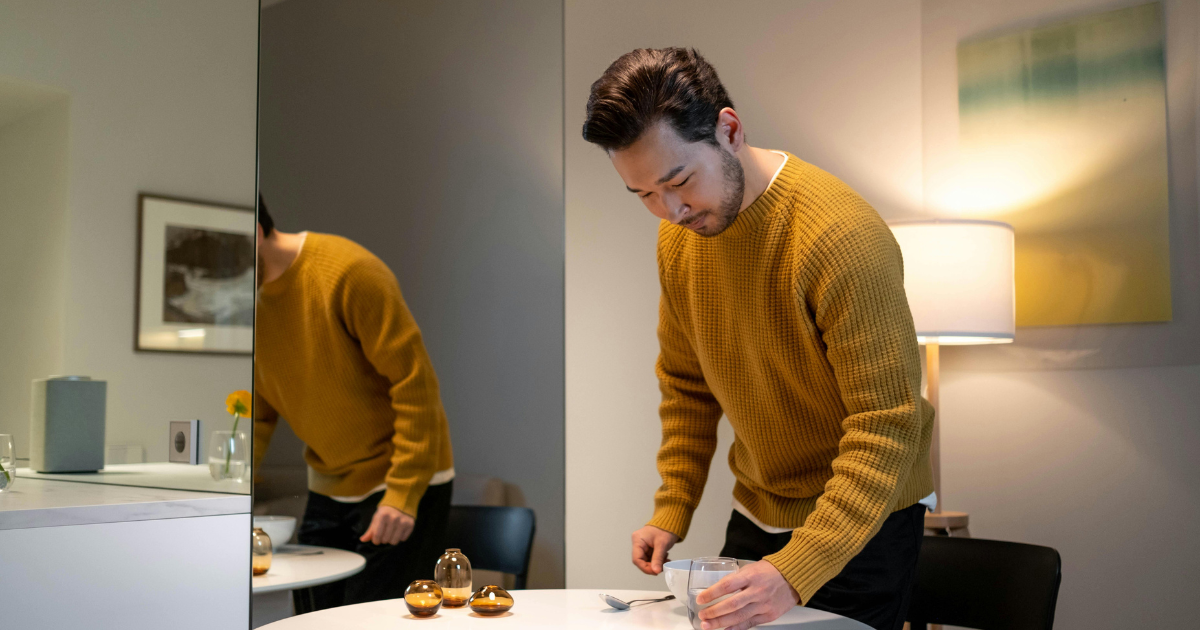 Image: Man happily doing housework at home, symbolizing affordable happiness after divorce or separation.