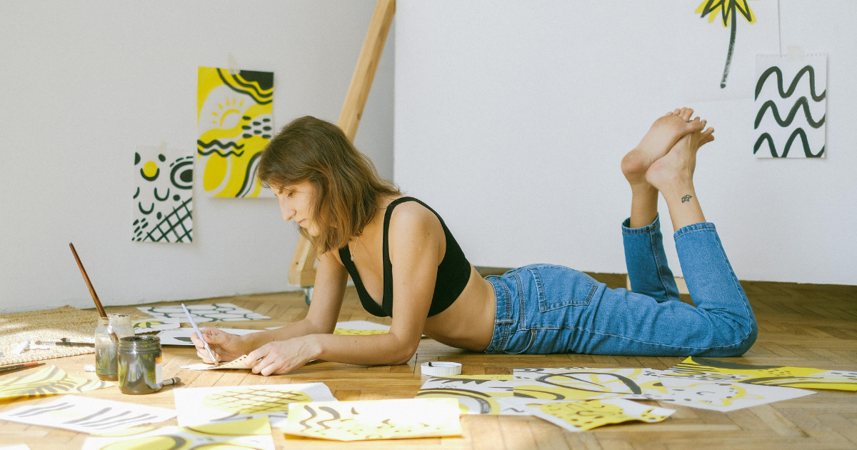 Image: A woman painting alone in a room, symbolizing rediscovering hobbies after a breakup