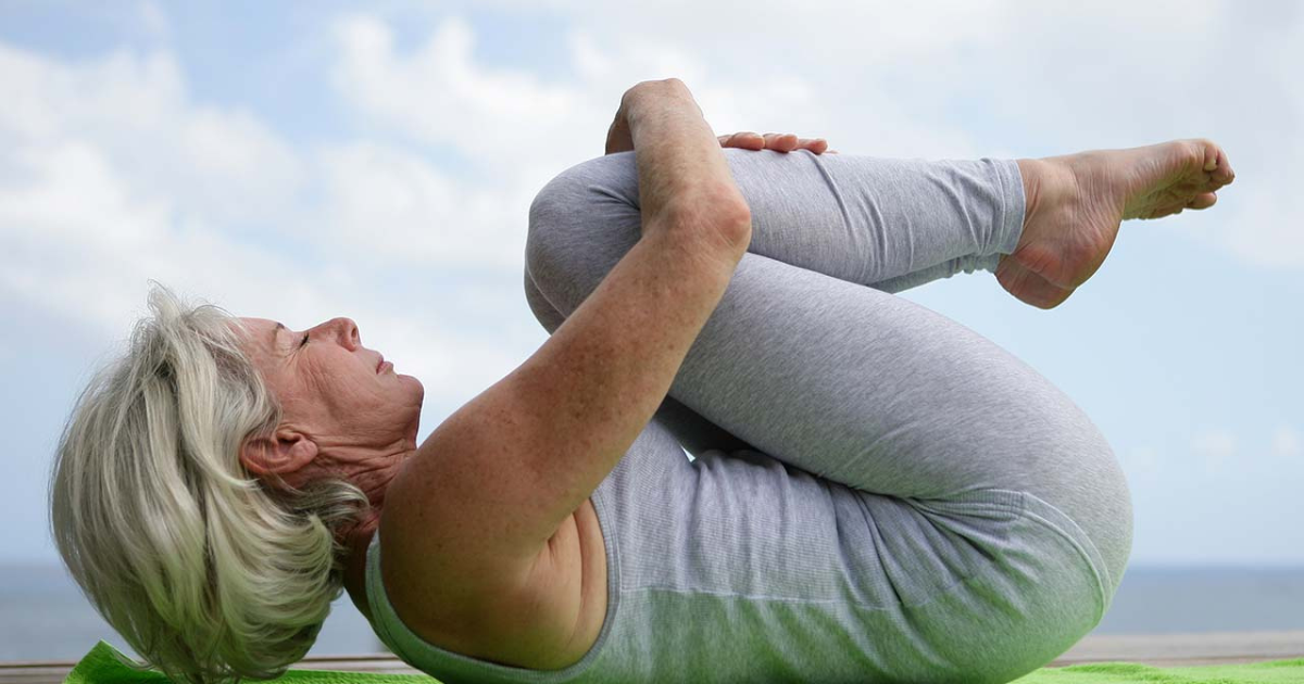 Image: Elderly woman practicing yoga as part of her beauty routine.