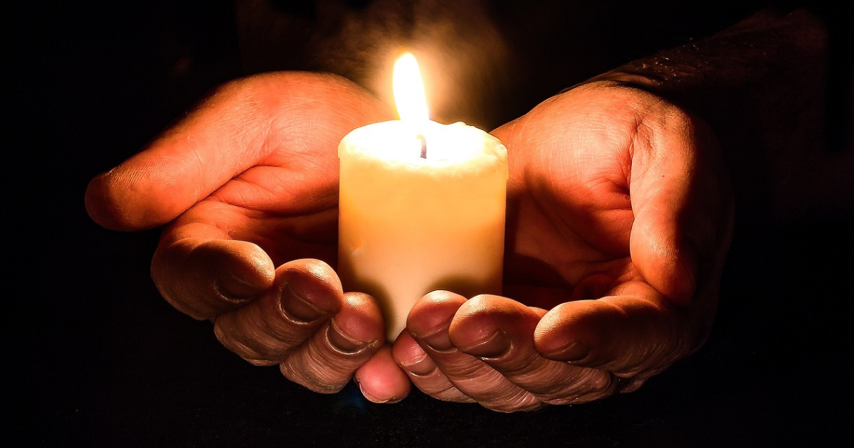 An image featuring hands holding burning candles, symbolizing the power of manifestation and Switchwords through the transformative energy of intention and light.