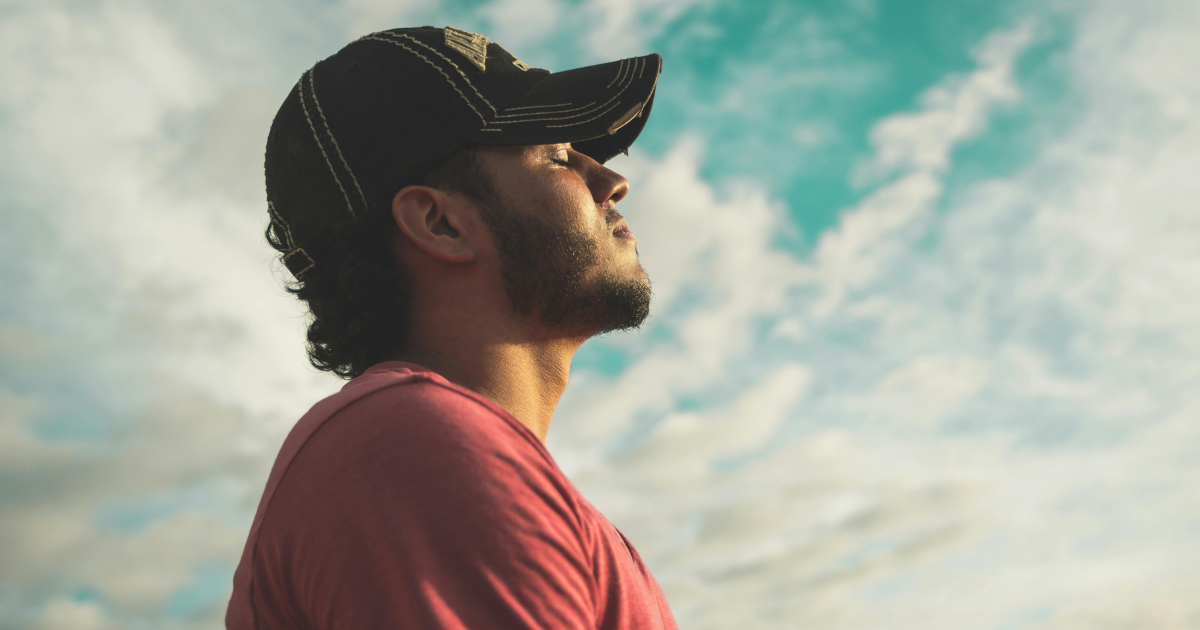 Man with closed eyes looking upward, depicting mindfulness in letting go