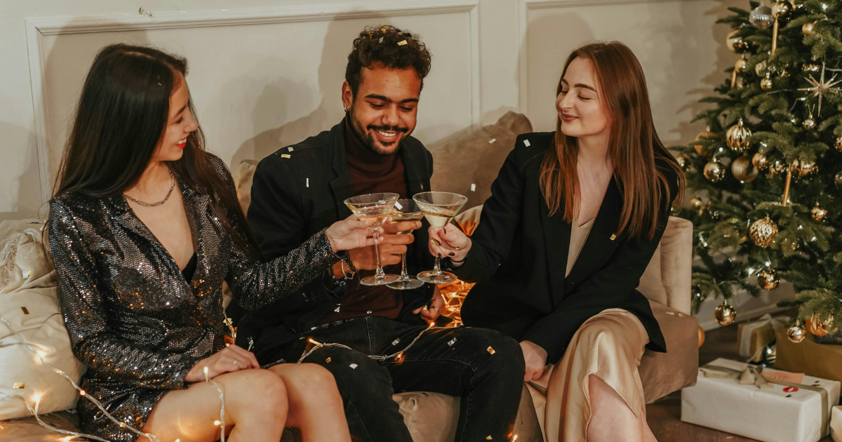 Three friends laughing and enjoying cocktails together, representing the joy of reconnecting with friends after divorce, finding solace and support in each other's company.