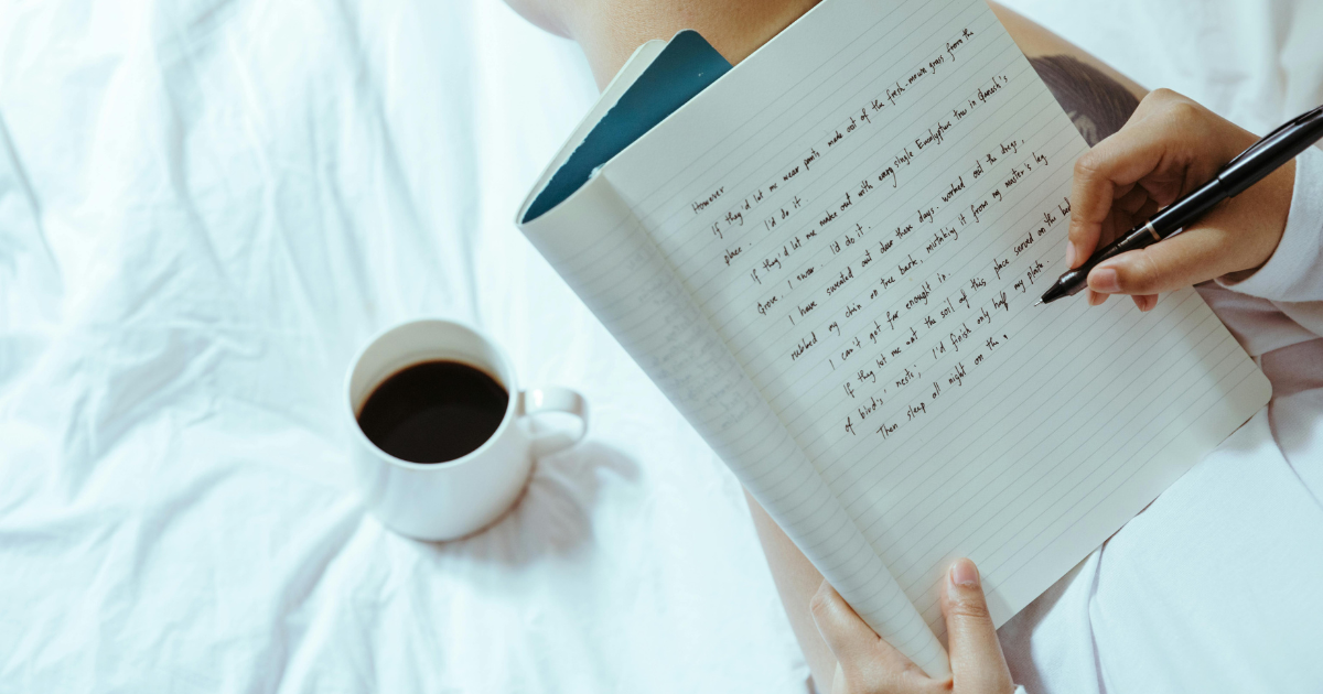 Image of a person writing, emphasizing writing as one of the best restorative options for overcoming 'bed rotting