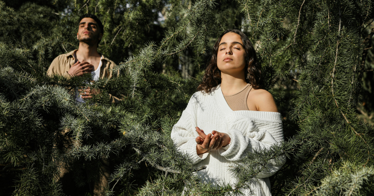 Two individuals meditating deeply in a deep wood, embracing Stoicism to release daily stress