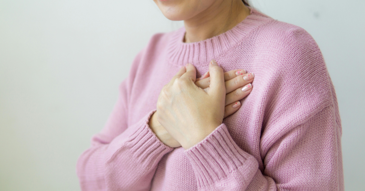 An image of two hands placed over the left chest, symbolizing compassion and empathy.