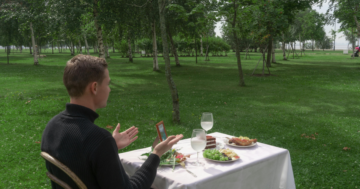 A man sitting at a dining table in a tranquil green environment, engaged in positive self-talk.