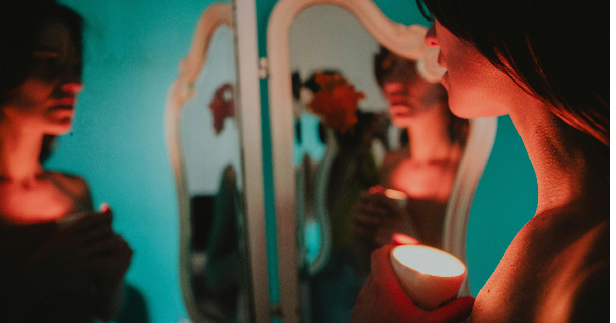 Woman looking at a mirror, symbolizing self-talk.