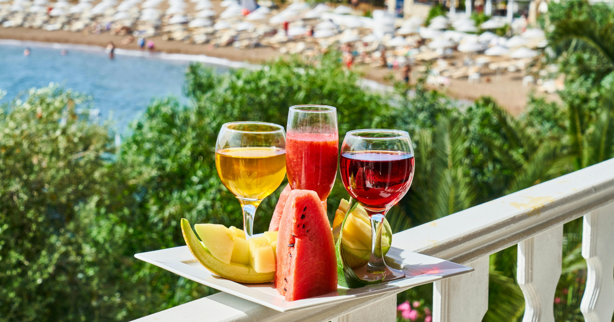 A tray with various juices and watermelon, highlighting the importance of staying refreshed during summer days