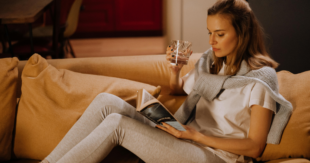 Image of a woman engrossed in reading a book in a silent room, enjoying her own timelines and space, highlighting the benefits of not getting married.