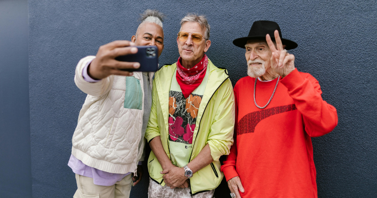 Three senior-aged men standing together and taking a selfie, highlighting the joy and importance of having fun at any stage of life.