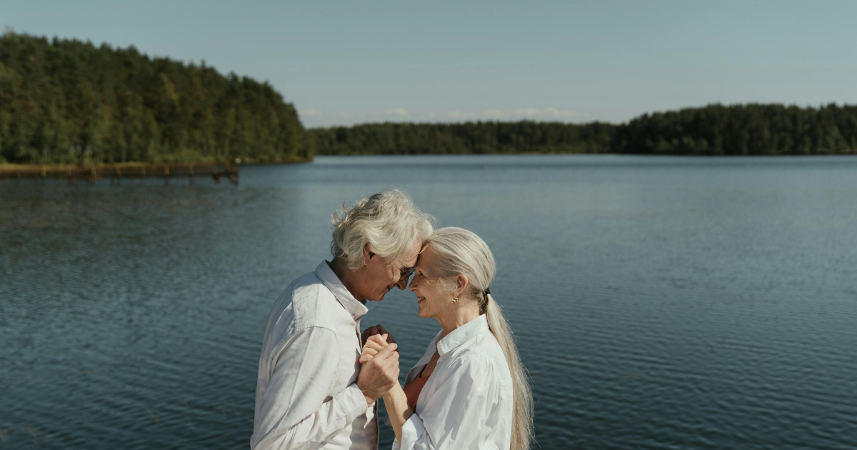 An elderly couple sharing a sweet moment by a stream, illustrating that there's no age limit for dating and cherishing special moments.