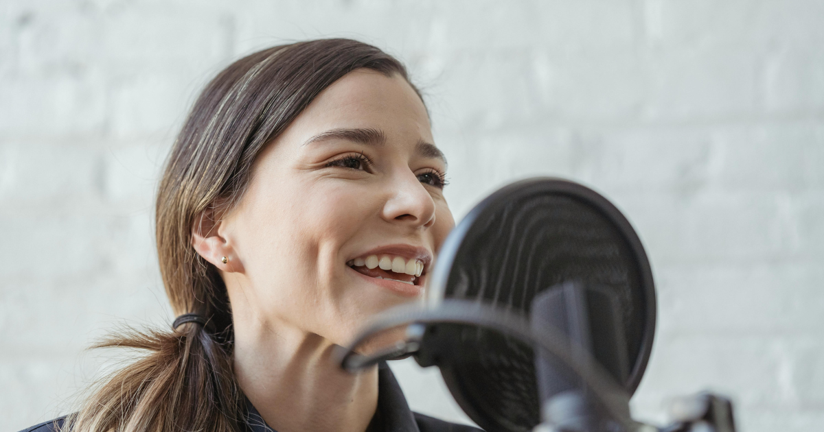 A joyful woman passionately tells a story using a stand microphone, illustrating the satisfaction and art of storytelling.