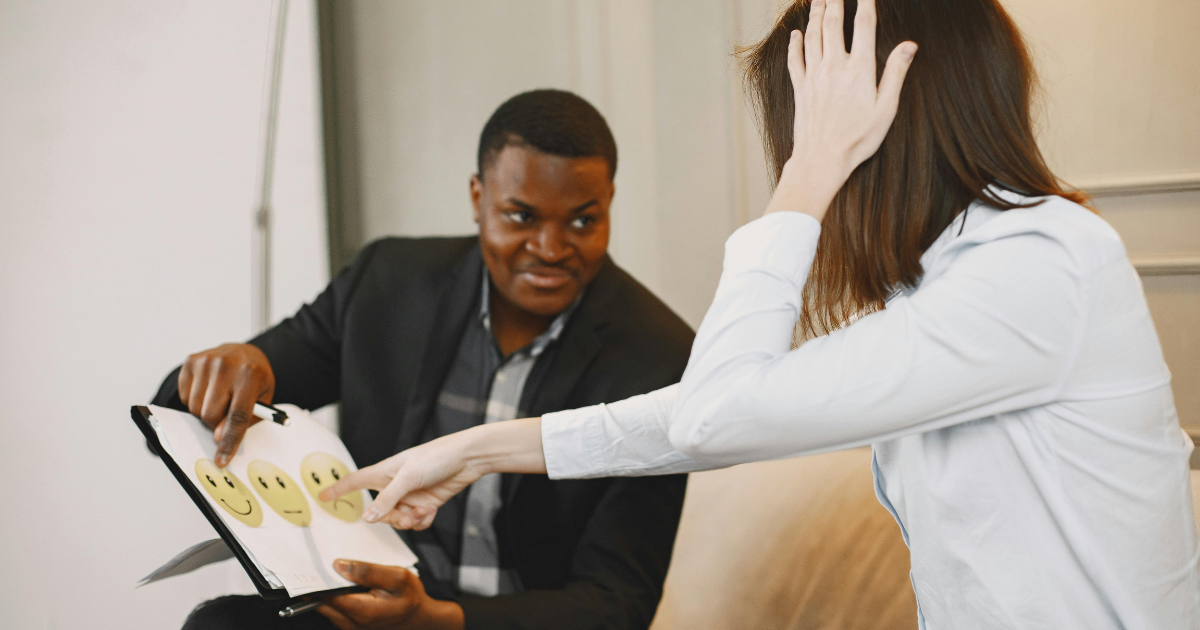 Two employees enjoying free time at the workplace, giggling and sharing a light moment, highlighting the importance of emotional intelligence in fostering a positive work environment.